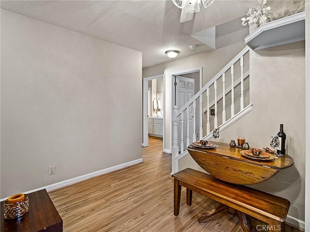 interior space featuring stairway, baseboards, and light wood finished floors