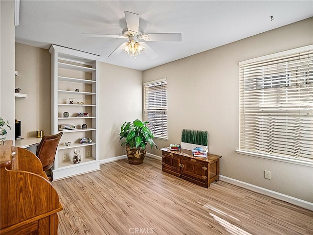 office area with light wood finished floors, baseboards, and a ceiling fan