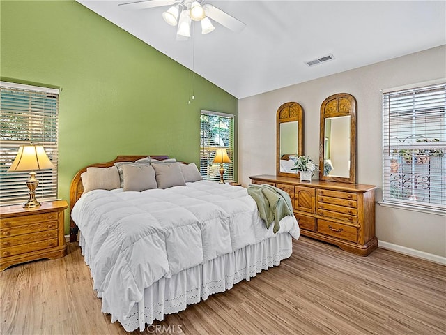 bedroom featuring visible vents, lofted ceiling, baseboards, and light wood finished floors