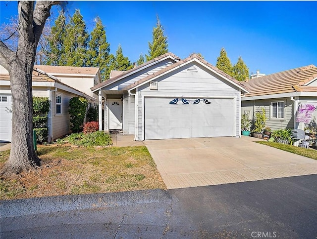 single story home with a tile roof, a garage, and driveway