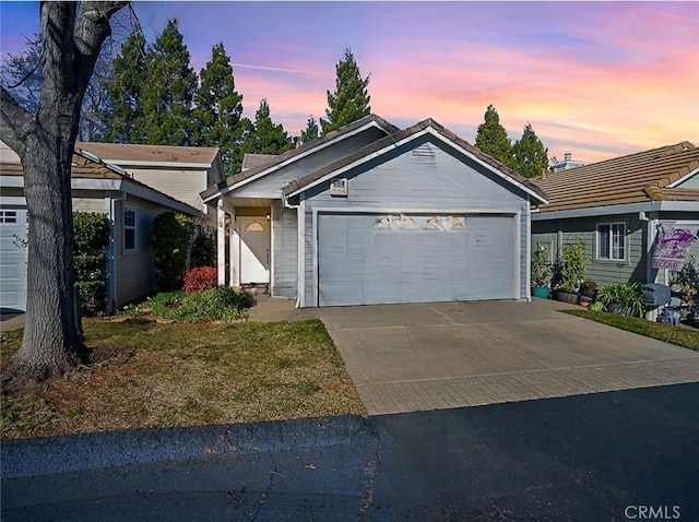 ranch-style house featuring concrete driveway and an attached garage