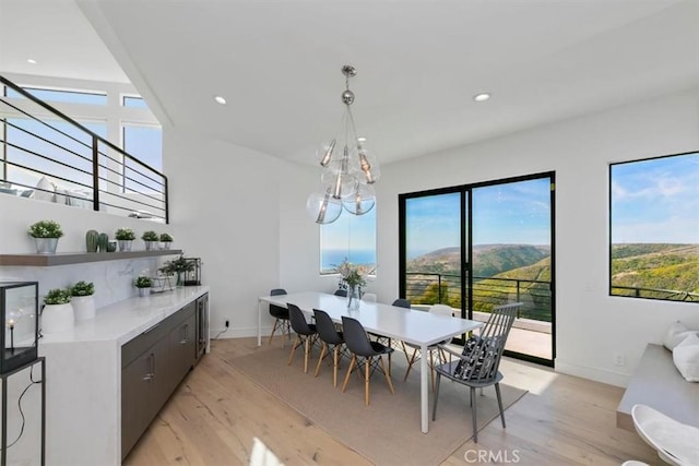 dining space featuring a mountain view, a chandelier, and light hardwood / wood-style floors