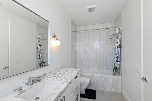 bathroom featuring visible vents, vanity, toilet, tiled shower / bath, and tile patterned floors