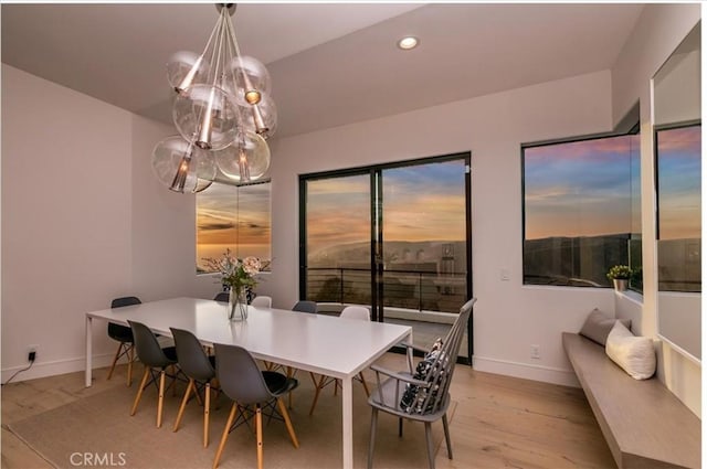 dining area with an inviting chandelier and light hardwood / wood-style flooring