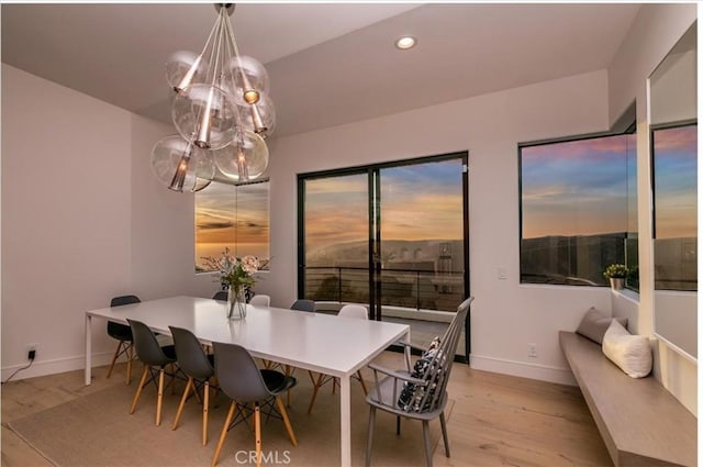 dining area featuring light wood-style floors, baseboards, recessed lighting, and a chandelier