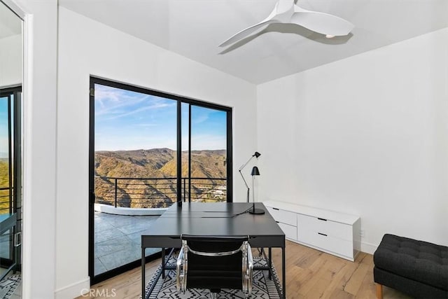 office area featuring ceiling fan, a mountain view, plenty of natural light, and light wood-style flooring