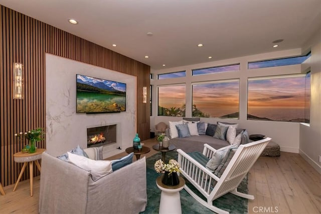 living area with wood-type flooring, recessed lighting, baseboards, and a high end fireplace