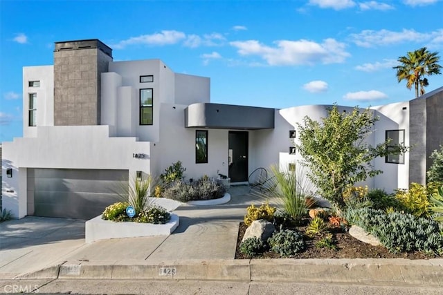 contemporary house with a garage, stucco siding, and driveway