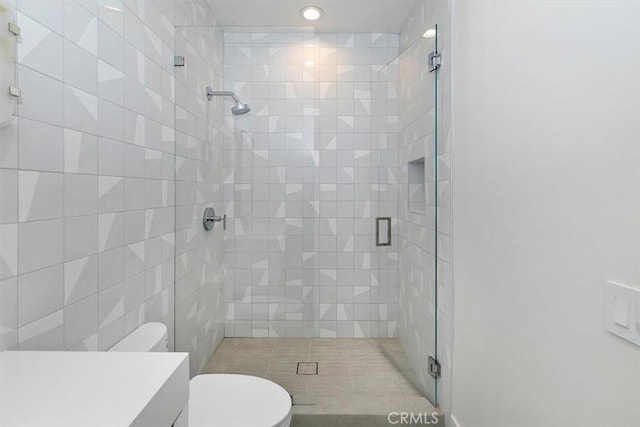 bathroom with recessed lighting, a stall shower, toilet, and vanity