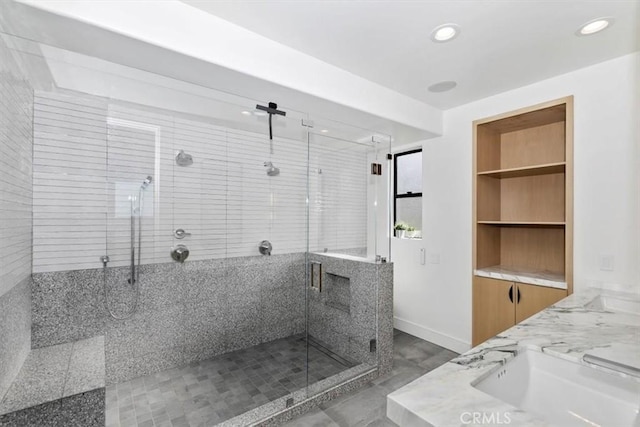 bathroom featuring a sink, baseboards, a shower stall, and recessed lighting