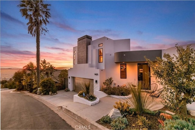 view of front facade featuring an attached garage, driveway, and stucco siding