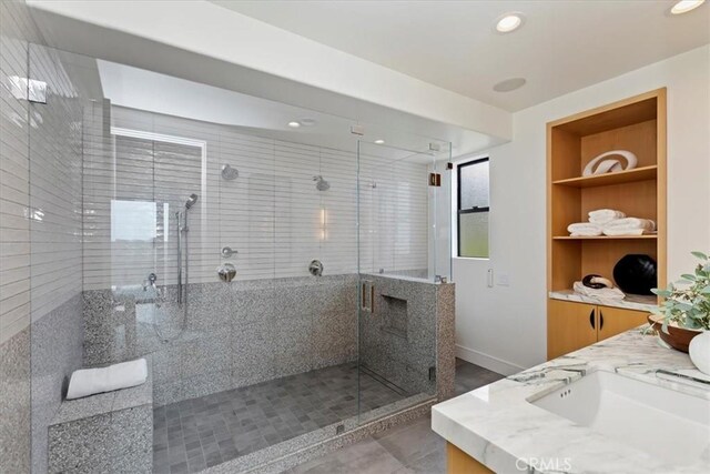1425 Skyline Dr, Laguna Beach, CA 92651 - bathroom featuring a stall shower, built in shelves, double vanity, recessed lighting, and tile patterned flooring