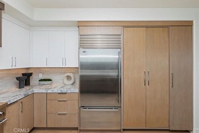 1425 Skyline Dr, Laguna Beach, CA 92651 - kitchen featuring built in fridge, decorative backsplash, light stone counters, and white cabinets