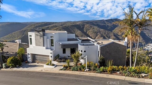 1425 Skyline Dr, Laguna Beach, CA 92651 - modern home with a mountain view, an attached garage, concrete driveway, and stucco siding