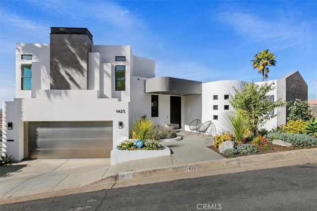 1425 Skyline Dr, Laguna Beach, CA 92651 - view of front of home with stucco siding, an attached garage, and driveway