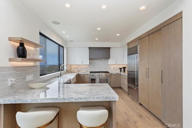 1425 Skyline Dr, Laguna Beach, CA 92651 - kitchen featuring high quality appliances, a peninsula, open shelves, a kitchen breakfast bar, and wall chimney range hood