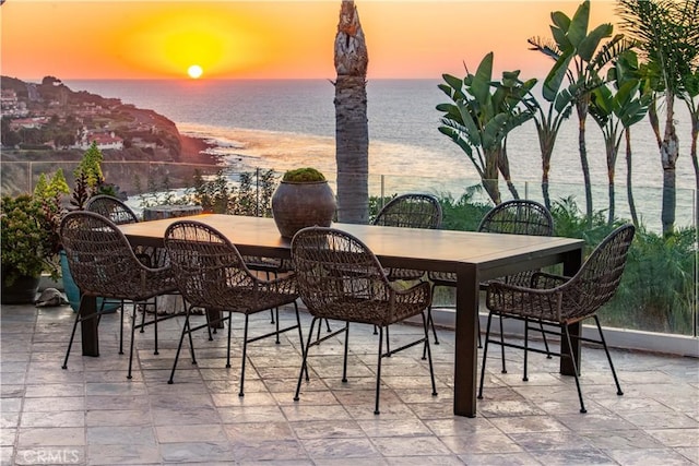 patio terrace at dusk featuring a water view