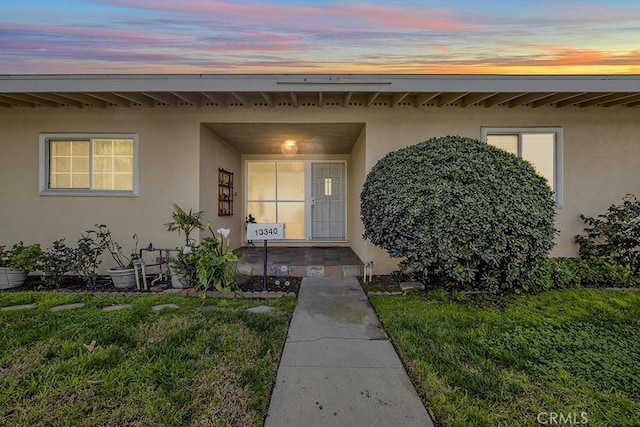 exterior entry at dusk with a lawn