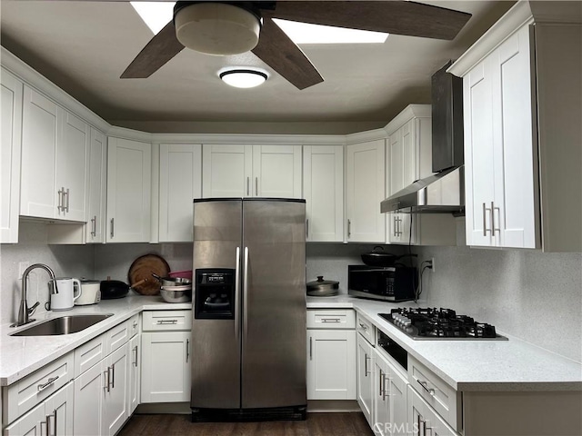 kitchen with appliances with stainless steel finishes, sink, white cabinetry, ceiling fan, and dark wood-type flooring