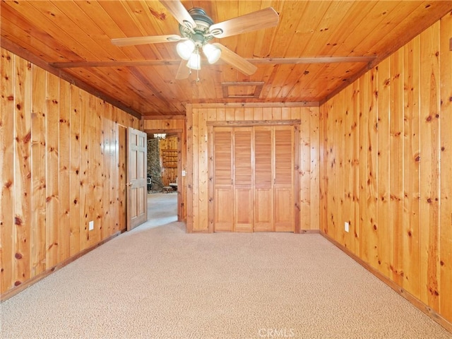 unfurnished bedroom with wood walls, carpet floors, and wooden ceiling