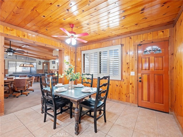 tiled dining space featuring ceiling fan, wood walls, and wooden ceiling