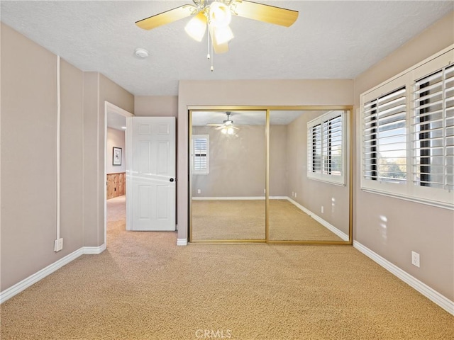 unfurnished bedroom featuring ceiling fan, carpet, a textured ceiling, and a closet