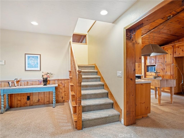 stairs with wood walls and carpet