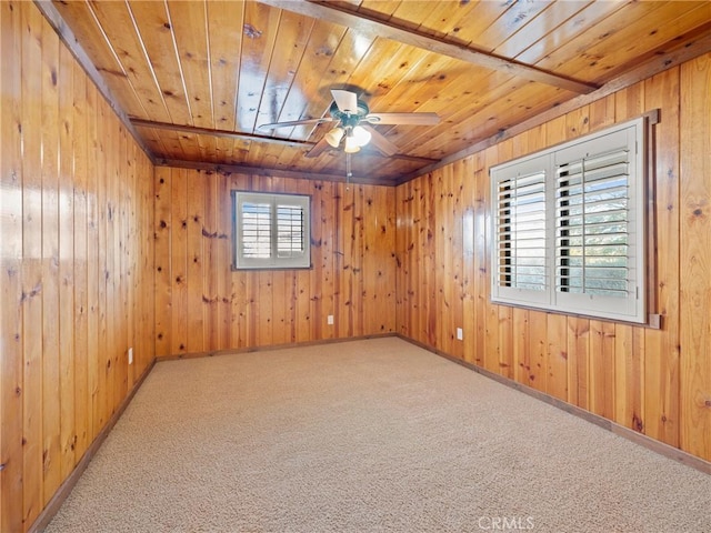 carpeted empty room with wooden ceiling, ceiling fan, and wood walls