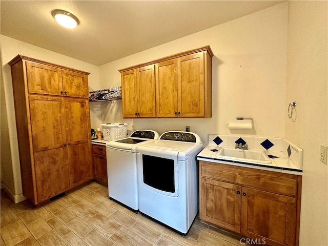 washroom with independent washer and dryer, cabinets, and sink