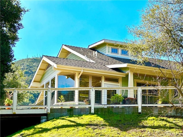 rear view of property featuring a lawn