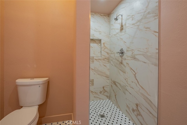 bathroom featuring toilet and a tile shower