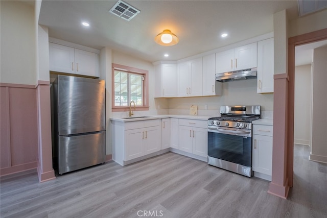 kitchen featuring light wood-type flooring, stainless steel appliances, sink, and white cabinets