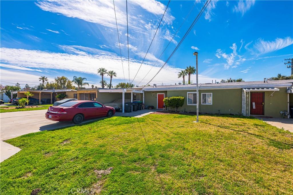 single story home featuring driveway, a front yard, and stucco siding
