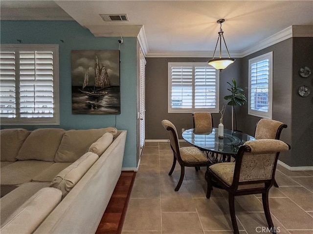 dining area with baseboards, ornamental molding, and visible vents