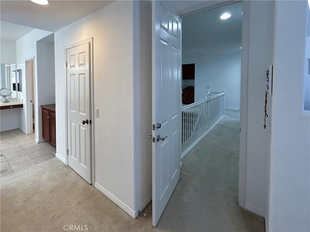 hall featuring light colored carpet, baseboards, and recessed lighting