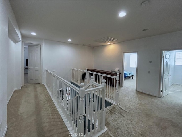 hallway featuring carpet flooring, baseboards, an upstairs landing, and recessed lighting