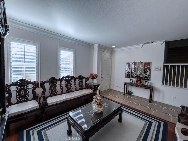 living room featuring visible vents, a textured ceiling, and crown molding