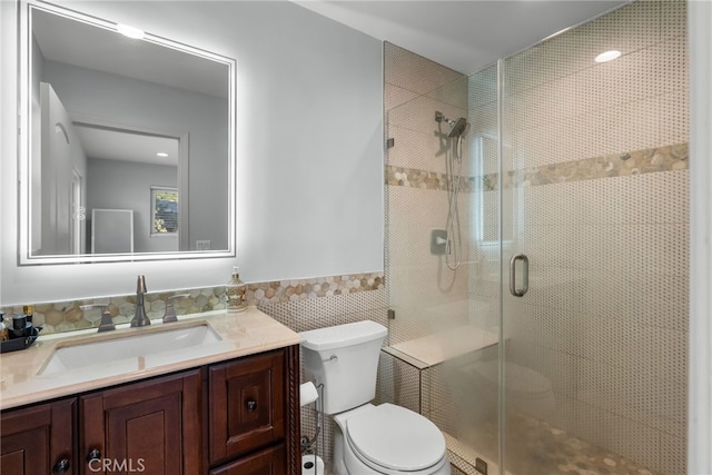 bathroom with vanity, tile walls, an enclosed shower, and toilet