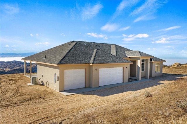 exterior space featuring cooling unit, a garage, and a mountain view