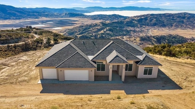 view of front of home with a mountain view and a garage