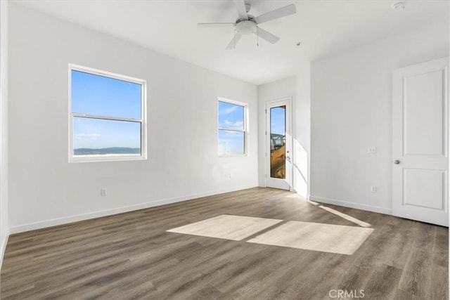 empty room with dark wood-type flooring and ceiling fan