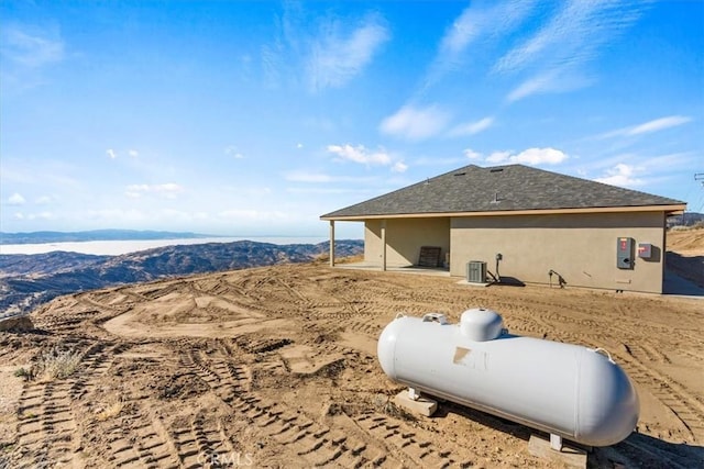 view of property exterior featuring central AC unit and a mountain view