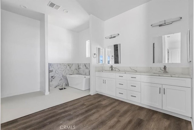 bathroom featuring vanity, hardwood / wood-style floors, tile walls, and a tub