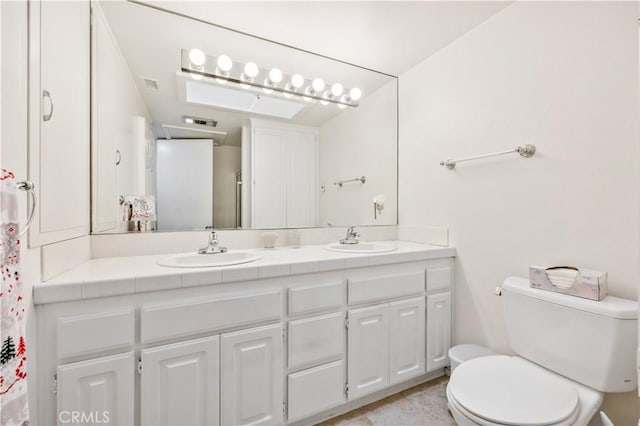 bathroom with visible vents, a sink, toilet, and double vanity