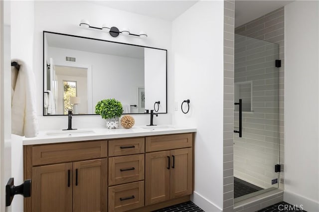 bathroom with a sink, visible vents, a stall shower, and double vanity