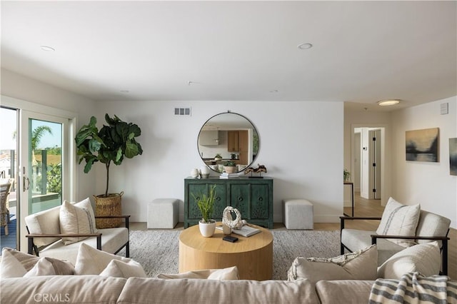 living room with visible vents, recessed lighting, and wood finished floors