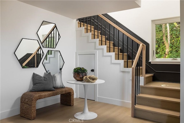 stairs with wood finished floors and baseboards