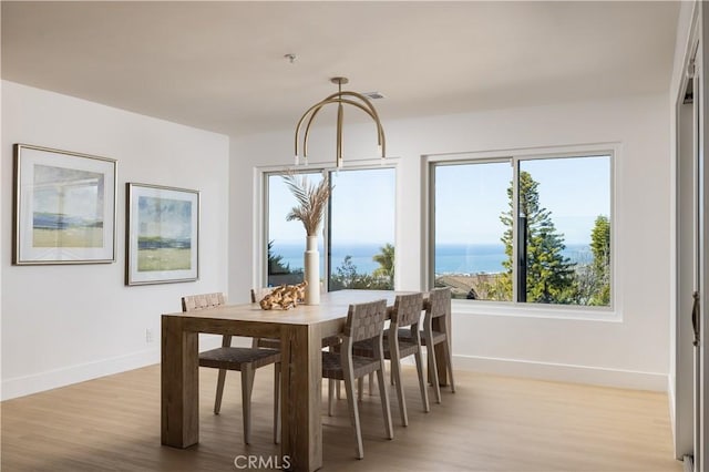 dining area with baseboards and light wood-style floors