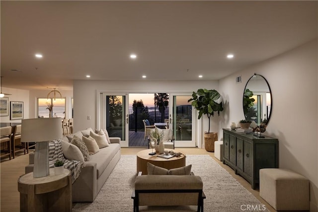 living area with light wood-style flooring, recessed lighting, and visible vents