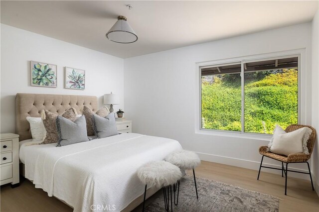 bedroom featuring wood finished floors and baseboards